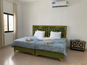 Arabian Nights Nook في مسقط: غرفة نوم عليها سرير وفوط