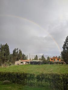 a rainbow in the sky over a field at Casa de Campo Moderna Ubaté - Sector La Laja in Ubaté