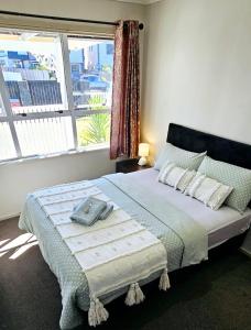 um quarto com uma cama grande e uma janela em Miami Stay em Auckland