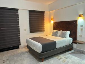 a bedroom with a large bed with black blinds at Ixaya in Puerto Vallarta