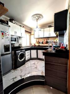 cocina con lavadora y lavavajillas en Appartement luxe et confortable à côté de aswak, en Oujda