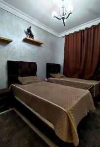 een slaapkamer met 2 bedden en een kroonluchter bij Appartement luxe et confortable à côté de aswak in Oujda