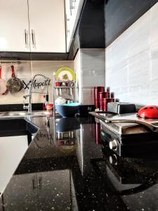 een keuken met een zwart aanrecht in een keuken bij Appartement luxe et confortable à côté de aswak in Oujda