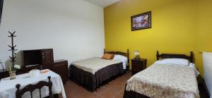 a hotel room with two beds and a tv at HOSTAL BOLIVIA EN YACUIBA in Yacuiba