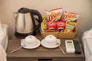 a table with two cups and a coffee maker and snacks at ALEX HOTEL and SPA in An Bàn (2)