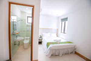 a bedroom with a bed and a shower and a sink at ALEX HOTEL and SPA in An Bàn (2)