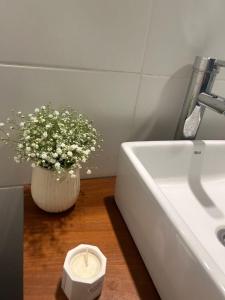 a vase of flowers sitting next to a sink at El Establo City Bell - solo alojamiento in City Bell
