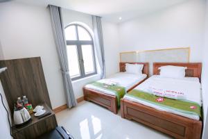 a small room with two beds and a window at ALEX HOTEL and SPA in An Bàn (2)
