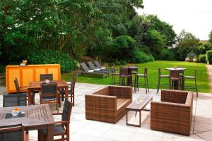 une terrasse avec des tables et des chaises ainsi qu'une pelouse. dans l'établissement Portsmouth Marriott Hotel, à Portsmouth