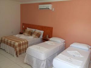 a hotel room with two beds and a heater at Pousada Brisa Do Pontal in Fortim