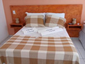 a bedroom with a bed with two white towels on it at Pousada Brisa Do Pontal in Fortim