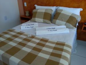 a bed with two pillows on top of it at Pousada Brisa Do Pontal in Fortim
