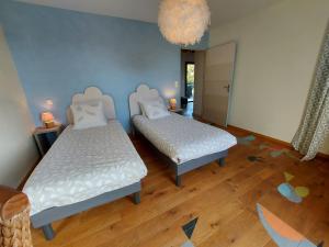 1 dormitorio con 2 camas y lámpara de araña en Gîte Ménil, 3 pièces, 4 personnes - FR-1-600-244, en Ménil