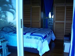 a bedroom with a bed and a glass door at TahitiSylvie Home in Aua +26 photos