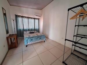 een slaapkamer met een bed in een kamer met een raam bij Cabina Privada en Segundo piso con piscina, a 2 min caminando de la playa in Brasilito