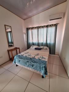 een slaapkamer met een bed in een kamer met een raam bij Cabina Privada en Segundo piso con piscina, a 2 min caminando de la playa in Brasilito