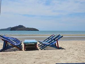 two chairs and a table on the beach at Ocean Blue Huahin Guesthouse in Hua Hin