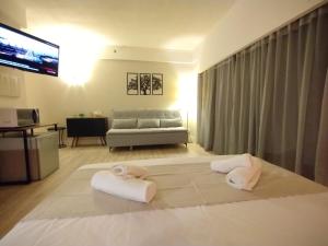 una sala de estar con una cama con toallas. en UH 905 Flat Live Logde Vila Mariana Pq Ibirapuera, en São Paulo