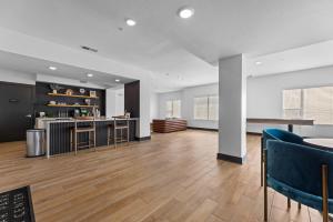 an empty living room with a kitchen and a bar at Cozy 2B Apartment with great Amenities in the Heart of Cedar Park in Cedar Park