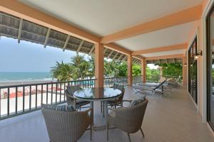 balcón con mesa, sillas y vistas al océano en Anantasila Beach Resort Hua Hin, en Hua Hin