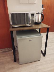 a microwave and a refrigerator sitting on a table at UH 905 Flat Live Logde Vila Mariana Pq Ibirapuera in São Paulo