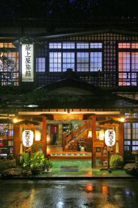 un bâtiment de nuit avec des panneaux devant lui dans l'établissement Mogamiya Ryokan, à Shiroishi