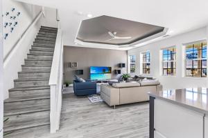 a living room with a staircase and a couch at Chic & Cozy River District Townhouse in Fort Myers