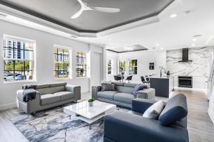 a living room with two couches and a kitchen at Chic & Cozy River District Townhouse in Fort Myers