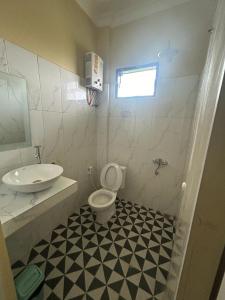 een badkamer met een toilet en een wastafel bij Kaesa Homestay in Berastagi