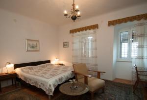 a bedroom with a bed and a chair at Apartment Villa Minach in Volosko