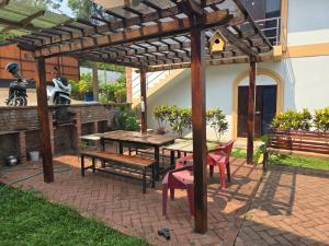 琅勃拉邦的住宿－#5 Appartement meublé + piscine.，一个带野餐桌和长椅的木制凉亭