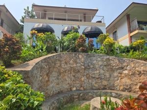 a stone retaining wall in front of a house at #5 Appartement meublé + piscine. in Luang Prabang
