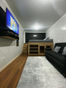 a living room with a couch and a flat screen tv at Hotel Canela 96 in Bogotá