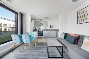 a living room with a couch and chairs and a kitchen at Penthouse w/ Hot Tub near Stratford, Westfield in London