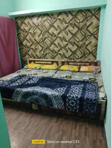 a bedroom with a bed with a blue comforter at Shivlok guest house Ujjain in Ujjain