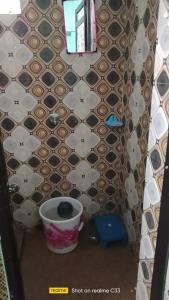 a small bathroom with a toilet and a tile wall at Shivlok guest house Ujjain in Ujjain
