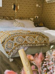 a bed with a blanket on top of it at Four caravan in AlUla