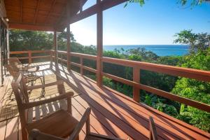 een veranda met stoelen en uitzicht op de oceaan bij Apricari Villa / Luxury Views / 5 BDRM / Pool in Roatan