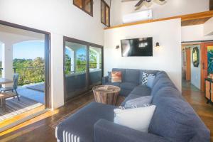 salon z niebieską kanapą i telewizorem w obiekcie Apricari Villa / Luxury Views / 5 BDRM / Pool w mieście Roatán