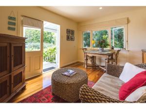 a living room with a couch and a table at Romantic Cottage Recommended by NZ Herald in Oneroa