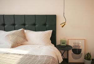 a bed with a green headboard in a bedroom at Hangzhou Spring B&B in Hangzhou