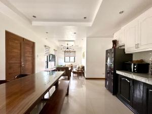 a kitchen with a large wooden table in a room at Bella Homes 6BR 4Bath near Rotunda in Tagaytay