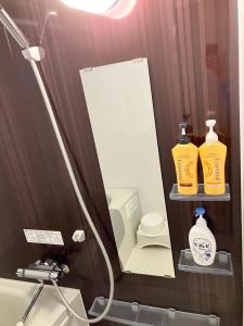 um espelho na casa de banho com duas garrafas de sabão em Happy Osaka House em Osaka