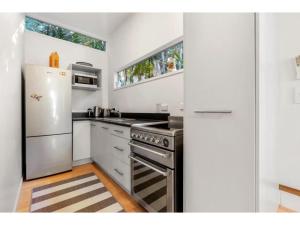 una cucina con piano cottura e frigorifero di Bellbird Paradise- Waiheke Escapes a Onetangi