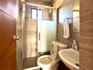 La petite salle de bains est pourvue de toilettes et d'un lavabo. dans l'établissement Bella Homes 6BR 4Bath near Rotunda, à Tagaytay