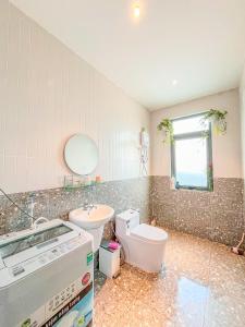 a bathroom with a toilet and a sink and a mirror at Moon Homestay TWO in Xuan An