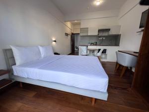 um quarto com uma grande cama branca e uma cozinha em 88th Nuwara Eliya em Nuwara Eliya