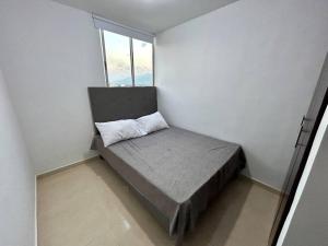 a small bed in a room with a window at Lindo apartamento de 3 habitaciones in Cúcuta