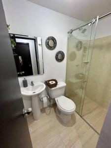 een badkamer met een toilet, een wastafel en een douche bij Lindo apartamento de 3 habitaciones in Cúcuta