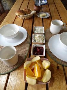 Artanish的住宿－Armenian Camp，木桌,盘子和碗水果及调味品